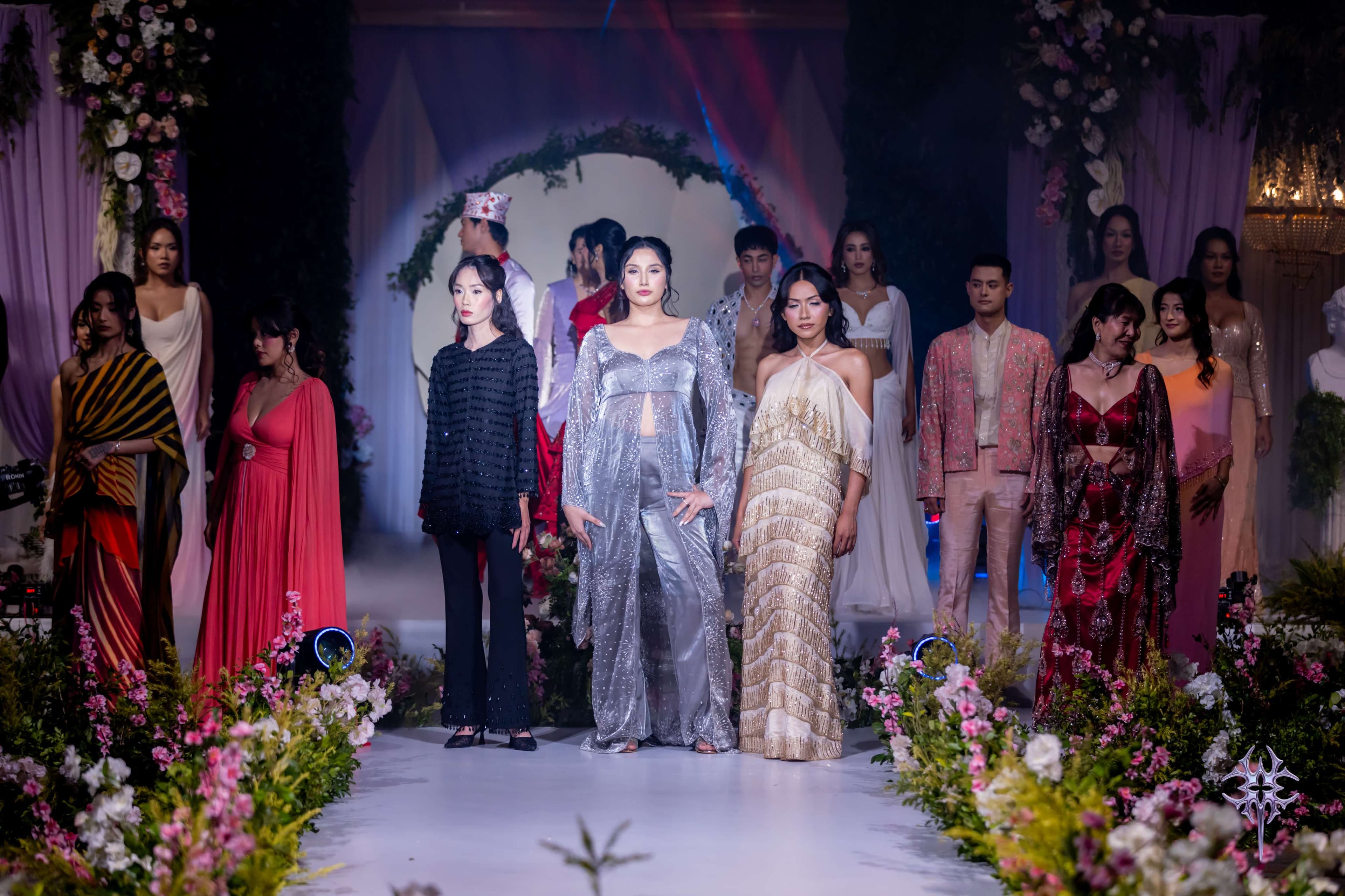 The full Asteria cast at the runway finale — sequined, embroidered and draped looks lining a flower-framed aisle